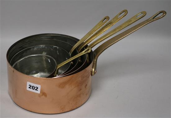 Five brass handled graduated copper saucepans